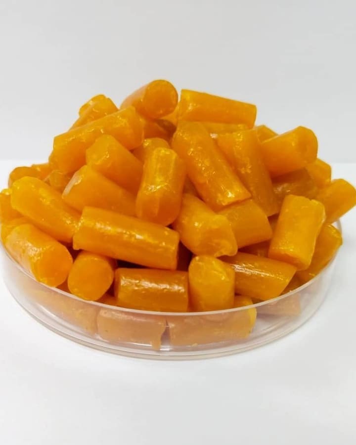 Amber soap noodles heaped in a glass dish.