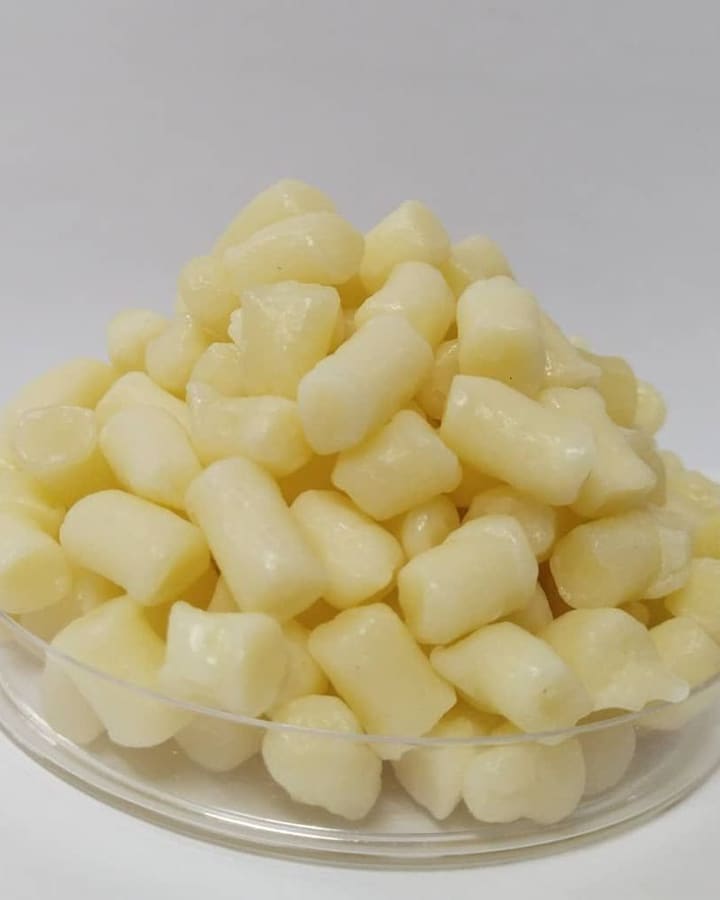 Cream-coloured soap noodles heaped in a glass dish.